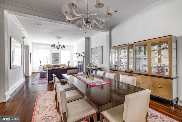 dining room featuring a notable chandelier, crown molding, dark wood-type flooring, and baseboards