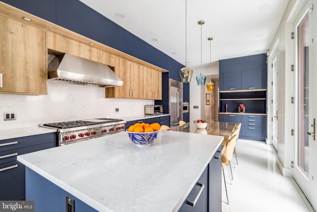 kitchen featuring a kitchen island, range with gas cooktop, hanging light fixtures, wall chimney exhaust hood, and built in fridge