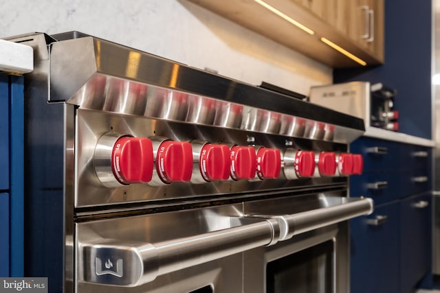 details with range with two ovens and blue cabinets