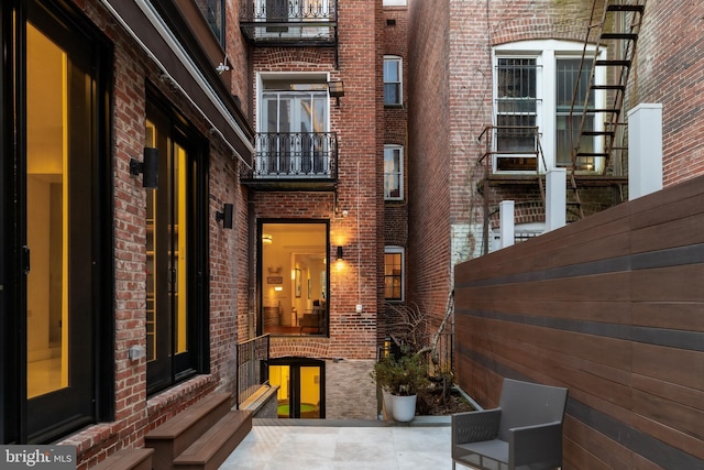 exterior space featuring brick siding and a balcony