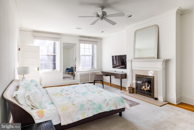 bedroom with visible vents, a fireplace, wood finished floors, and ornamental molding