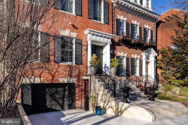 view of front facade featuring a garage, brick siding, and driveway