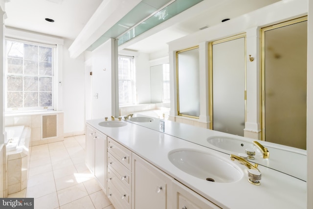 full bathroom with double vanity, a garden tub, a sink, and tile patterned flooring