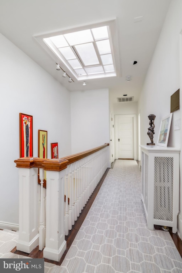 hall with an upstairs landing, visible vents, and a skylight