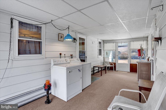 interior space with laundry area, separate washer and dryer, wood walls, and carpet flooring