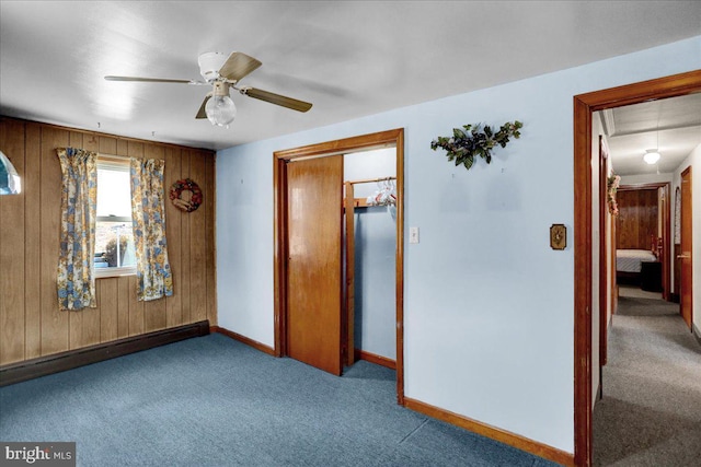 unfurnished bedroom featuring attic access, baseboards, a ceiling fan, carpet floors, and a baseboard heating unit