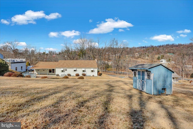 exterior space with an outbuilding, a shed, and a front lawn