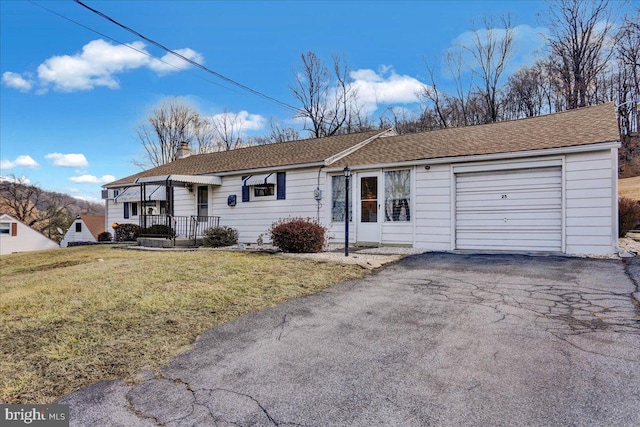 single story home with aphalt driveway, an attached garage, roof with shingles, a front lawn, and a chimney