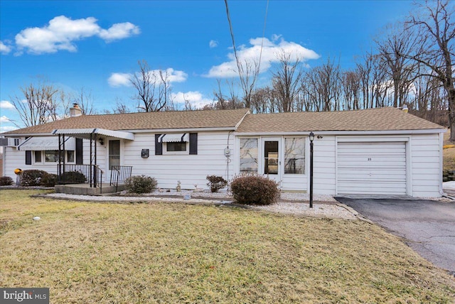 ranch-style home featuring aphalt driveway, a chimney, a shingled roof, a garage, and a front lawn