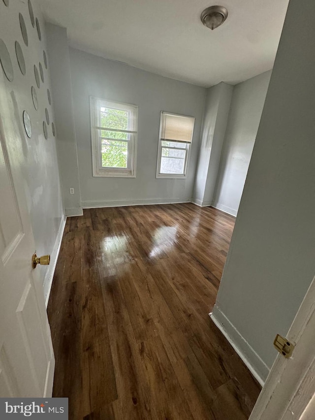 empty room with baseboards and wood finished floors