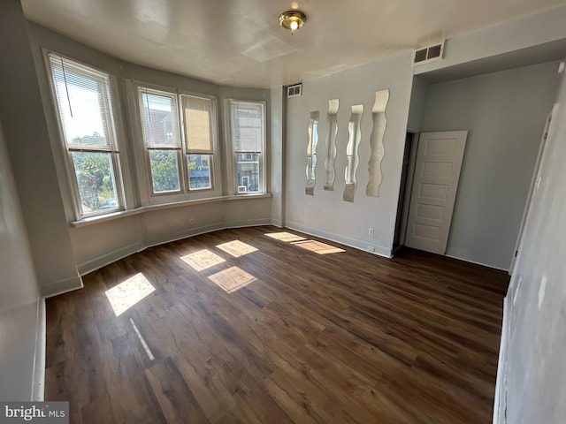 interior space featuring visible vents, dark wood finished floors, and baseboards