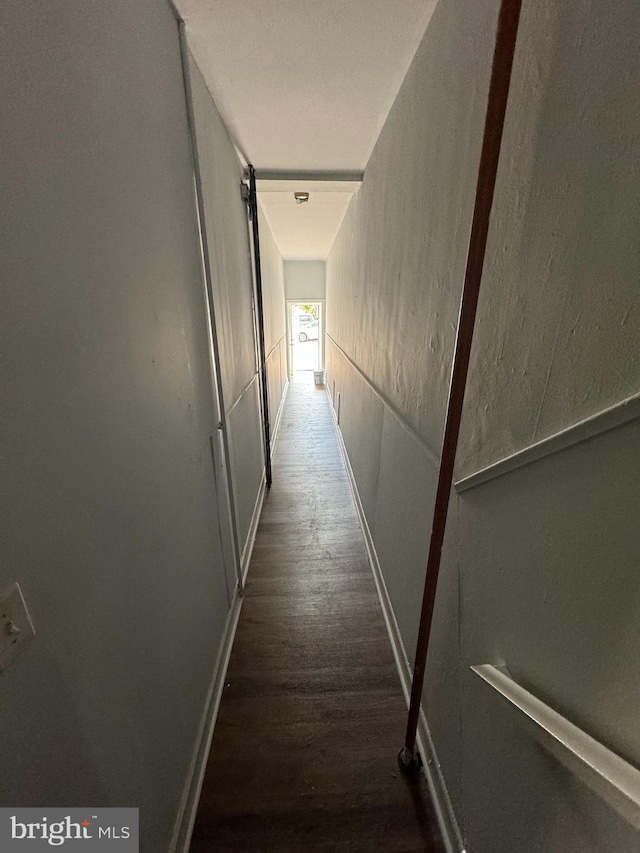 hall featuring wood finished floors and baseboards