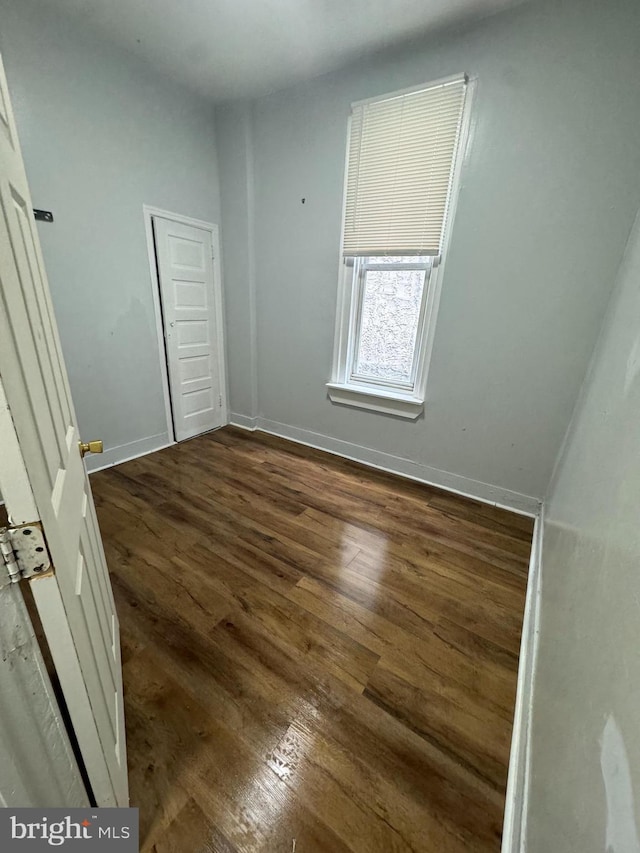 unfurnished bedroom featuring baseboards and dark wood finished floors