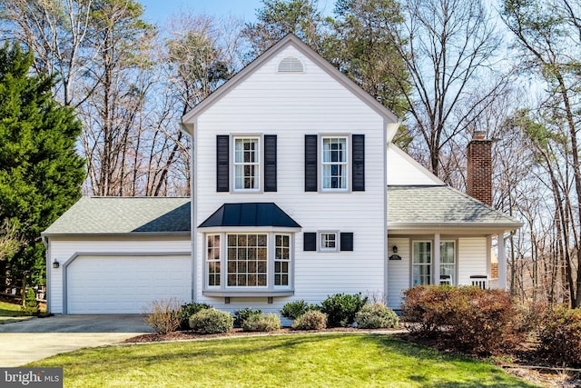 traditional-style house with a garage, a shingled roof, concrete driveway, a front lawn, and a chimney