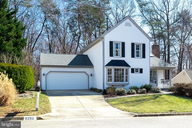 traditional home featuring driveway, a shingled roof, a chimney, an attached garage, and a front lawn