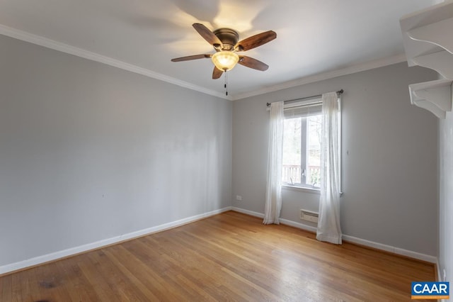 spare room with ornamental molding, ceiling fan, baseboards, and wood finished floors