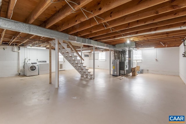 below grade area featuring water heater, washer and clothes dryer, heating unit, and stairs