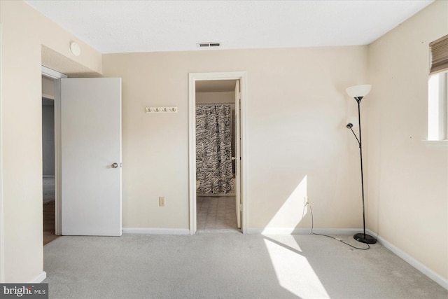 unfurnished bedroom featuring carpet flooring, visible vents, and baseboards