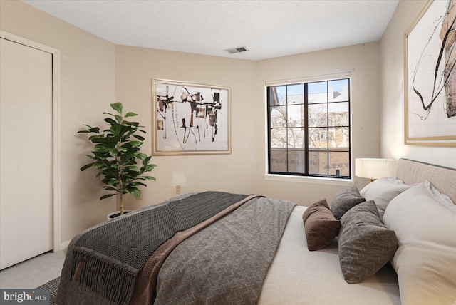 carpeted bedroom featuring visible vents and a textured ceiling