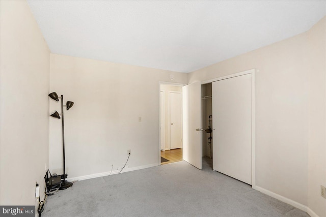 unfurnished bedroom featuring carpet, a closet, and baseboards