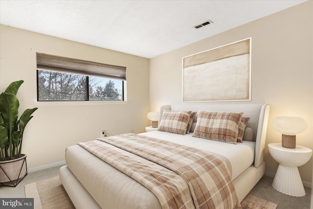 bedroom featuring carpet floors, baseboards, visible vents, and a textured ceiling