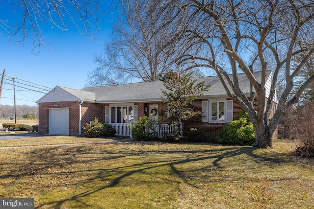 ranch-style home with driveway, brick siding, an attached garage, a porch, and a front yard