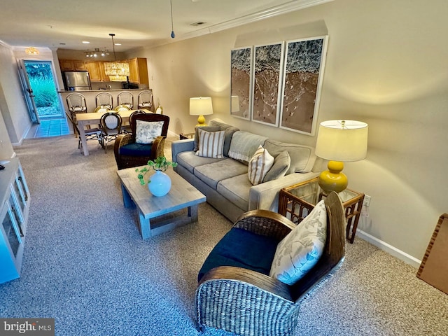 living room featuring baseboards, visible vents, ornamental molding, and light colored carpet