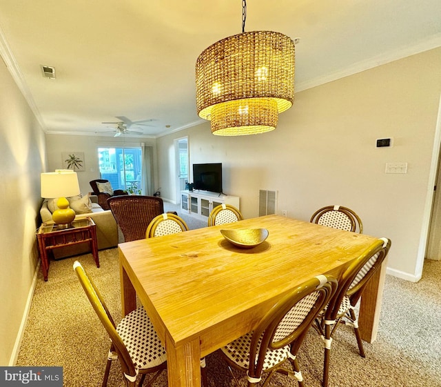 dining space with visible vents, baseboards, crown molding, and light colored carpet