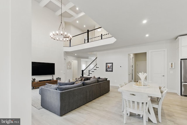 living room with light wood-style floors, stairway, coffered ceiling, and beam ceiling