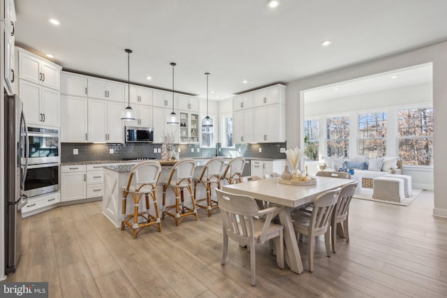 dining room with recessed lighting and light wood-style floors