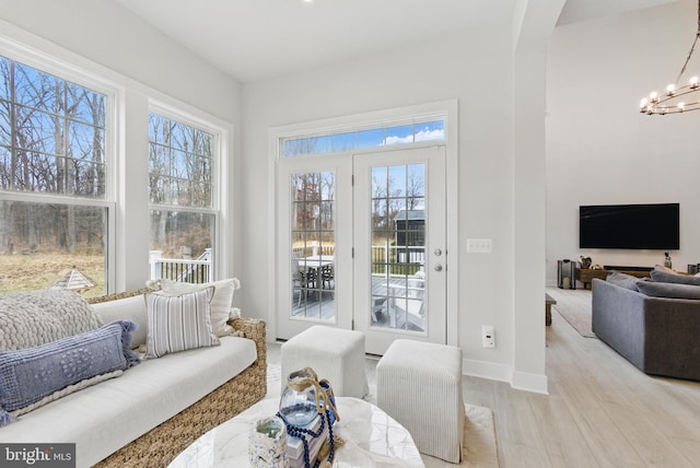 sunroom / solarium featuring a notable chandelier