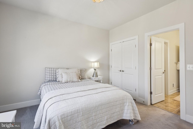 carpeted bedroom featuring baseboards and a closet