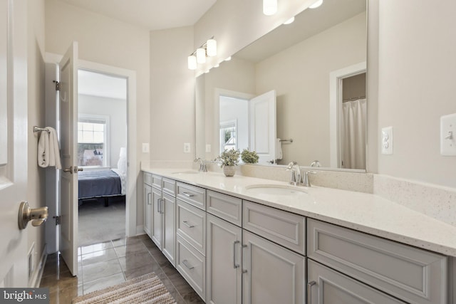 bathroom with double vanity, a sink, and tile patterned floors