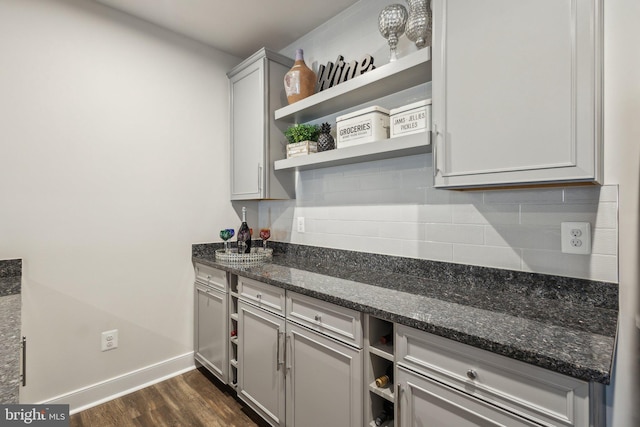 kitchen with tasteful backsplash, baseboards, dark stone counters, dark wood-style floors, and open shelves