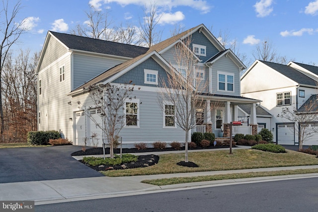 view of front facade featuring driveway, a garage, and a porch