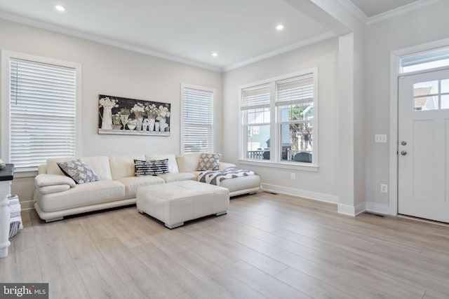 living area with ornamental molding, wood finished floors, a wealth of natural light, and baseboards