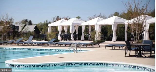 view of swimming pool featuring a gazebo, a patio area, and fence