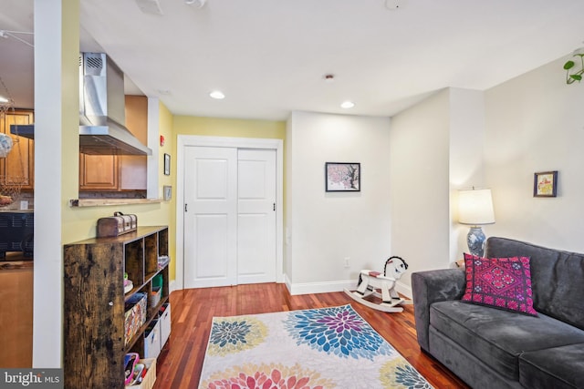 living area with recessed lighting, baseboards, and wood finished floors