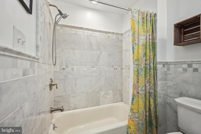 full bathroom with toilet, wainscoting, tile walls, and shower / bathtub combination with curtain