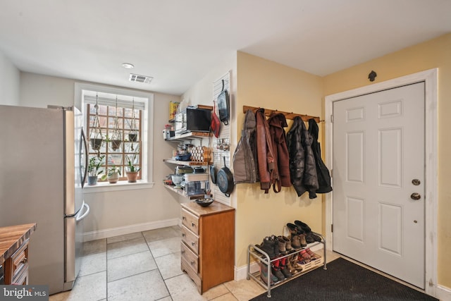 mudroom with visible vents, baseboards, and light tile patterned floors