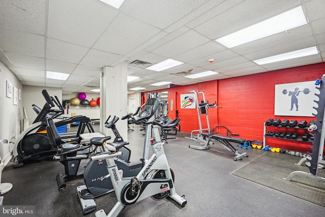 exercise room with a paneled ceiling and visible vents