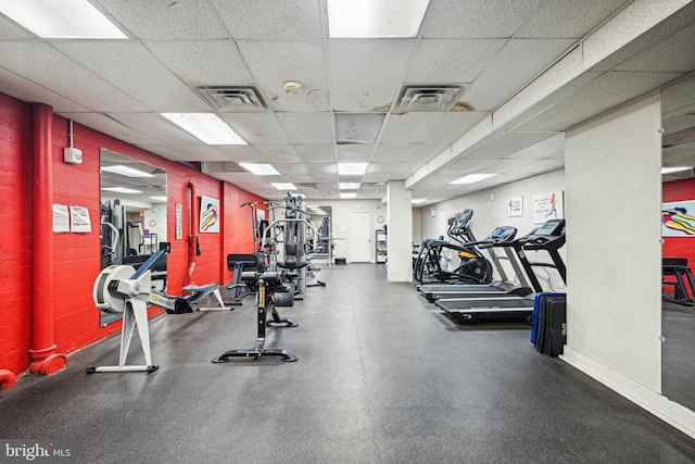 gym featuring visible vents, a drop ceiling, and baseboards