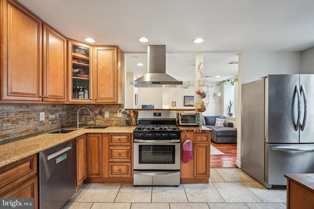 kitchen featuring appliances with stainless steel finishes, extractor fan, backsplash, and brown cabinetry