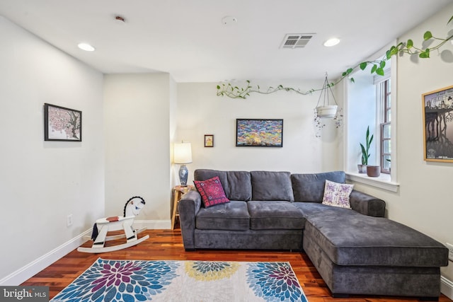 living room with recessed lighting, wood finished floors, visible vents, and baseboards