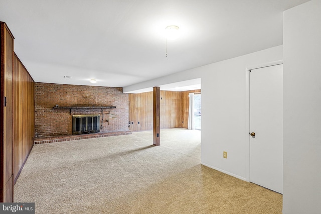 unfurnished living room featuring carpet flooring, a fireplace, and wood walls