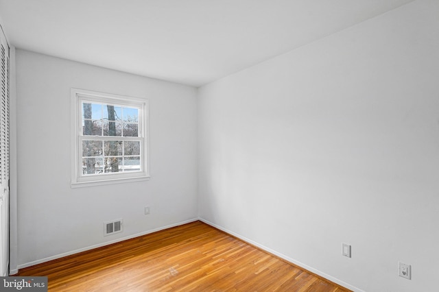 spare room featuring visible vents, baseboards, and light wood-style floors