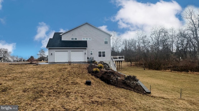 rear view of property featuring stairs, a yard, and aphalt driveway