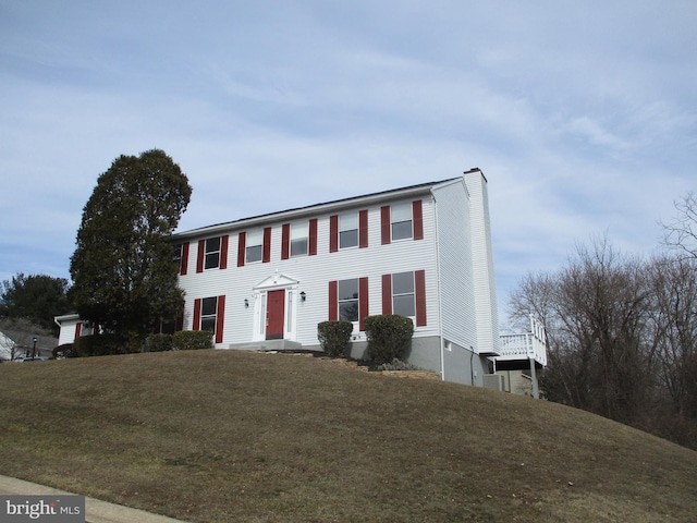 view of front facade with a chimney and a front yard