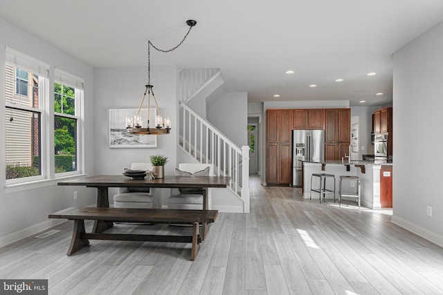 dining room with a chandelier, recessed lighting, baseboards, stairs, and light wood finished floors