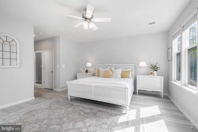 bedroom with light wood-type flooring, visible vents, and baseboards